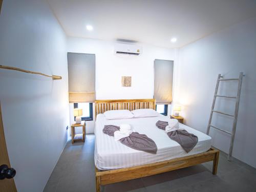 a bedroom with a bed with white sheets and a ladder at Villa Samuthra Lipa Noi in Koh Samui