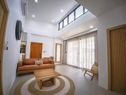 a living room with a couch and a table at Villa Samuthra Lipa Noi in Koh Samui