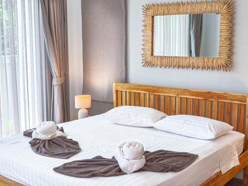 a bedroom with a bed with towels and a mirror at Villa Samuthra Lipa Noi in Koh Samui