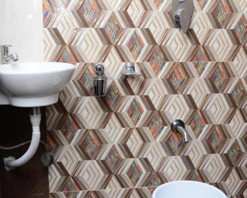 a bathroom with a sink and a mosaic wall at O C E A N Dormitory T-2 in Mumbai