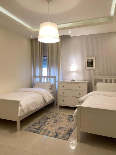 a bedroom with two beds and a chandelier at Ritala Royal Residence in Amman