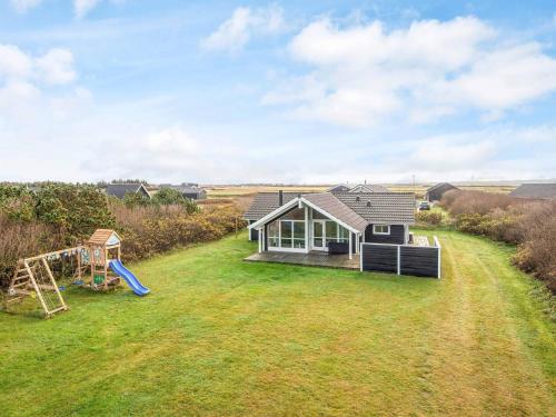 a small house with a playground in the yard at 8 person holiday home in Harboøre-By Traum in Harboør