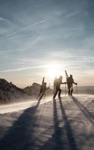 a group of people walking down a road with skis at Navigare Resorts in Saas-Fee