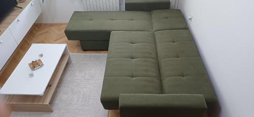 a living room with a green couch and a table at Stan so prekrasen pogled in Bitola