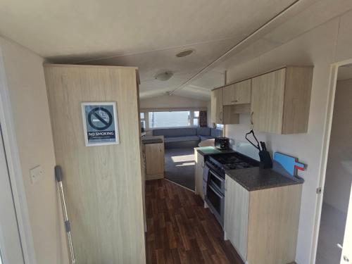 a small kitchen with wooden cabinets and a stove at Patricia 3 Bed Balcony in Rhyl in Rhyl