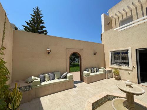 a patio with two couches and a table at La Villa Bleue Djerba Houmt Souk in Houmt Souk