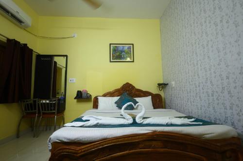 a bedroom with a bed with swans on it at ANAND LOK VATIKA in Rājgīr