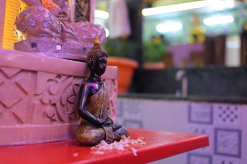 a statue of a person sitting on a red table at ANAND LOK VATIKA in Rājgīr