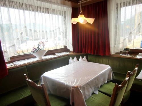 a dining room with a white table and windows at Pension Panorama in San Lorenzo di Sebato