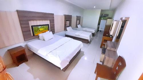 a bedroom with a large bed and a couch at Montana Hotel Kuningan in Panawuan