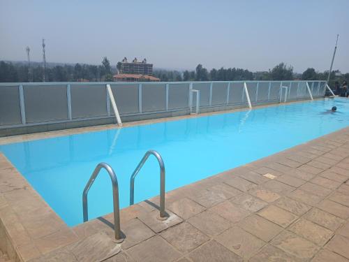a large swimming pool with blue water at Residence Next Door Green Zone in Kiambu