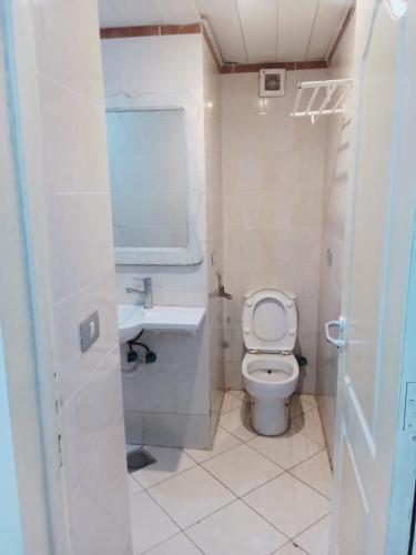 a white bathroom with a toilet and a sink at 321or322 the finest Porto Marina Chalets Tower 3 in El Alamein