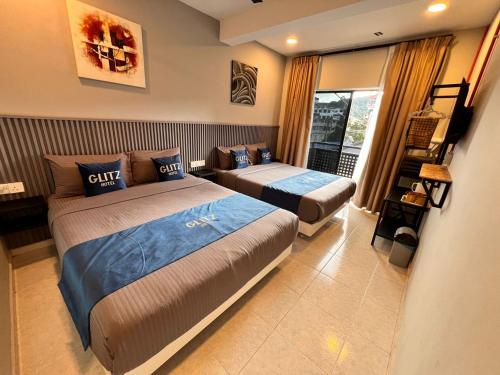 a bedroom with two beds and a window at Glitz Hotel in Brinchang