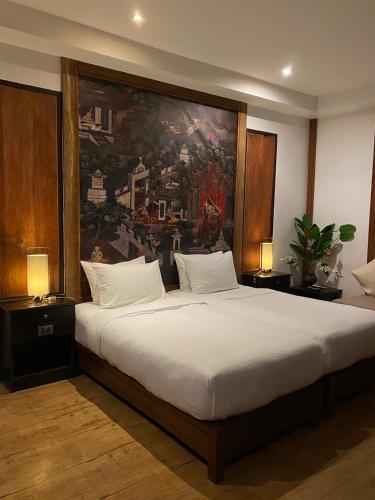 a bedroom with a large bed with a painting on the wall at Tukonnee Villas Koh Yao Noi in Ko Yao Noi