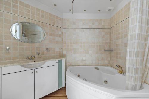 a bathroom with a tub and a sink and a mirror at 1469-N-Hornbaek-Kystvej-34-lej-2 in Hornbæk