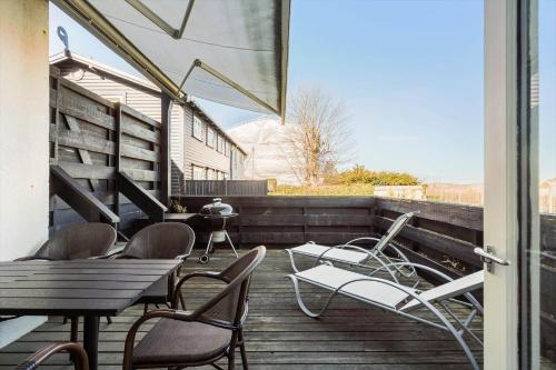 a patio with chairs and tables and a grill at 1469-N-Hornbaek-Kystvej-34-lej-2 in Hornbæk