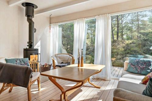 a living room with a table and a large window at 2707-Nexo-Th-Kofoedsvej-2 in Dueodde