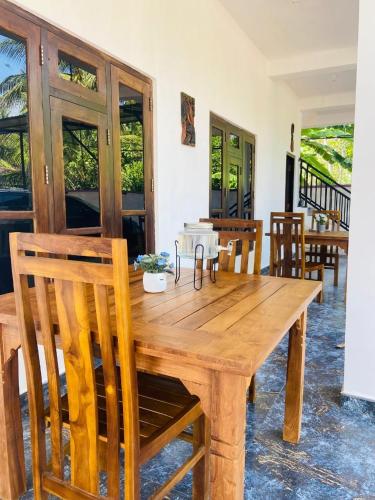 a wooden table and chairs in a room at Lodge in Resolute in Dambulla