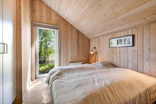 a bedroom with a bed in a room with a window at C11711-Hemmet-Strandvaenget-39 in Falen