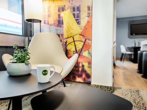a living room with a table and a chair at B&B Hotel Bielefeld-Ost in Bielefeld