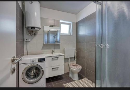 a bathroom with a washing machine and a toilet at Vila Didi in Fažana