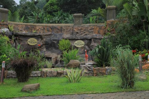 a garden with a stone wall and some plants at Hotel Bafana International in Nalakonge