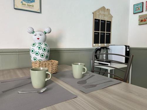 a table with two cups and a bunny statue on it at Portion of independent villa in Cinisello Balsamo