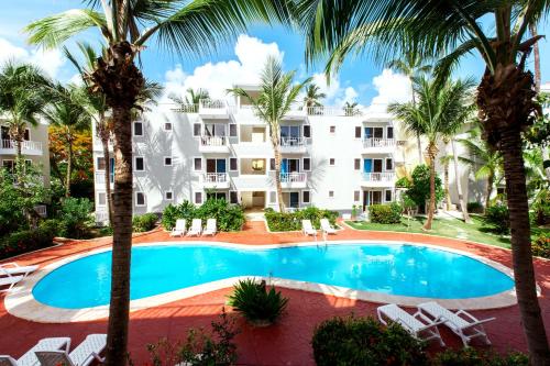 an image of a resort with a swimming pool and palm trees at CAMPO DEL MAR - STUDIOS and SUITES - LOS CORALES beach in Punta Cana