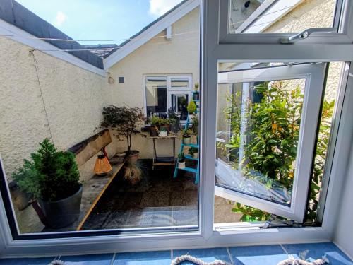 una puerta corredera de cristal abierta de un patio con mesa en Rosemount Guest Suite, en Grange-over-Sands