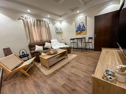 a living room with a couch and a table at Cozy 2-Bedroom Apartment in Batha Quraish in Makkah