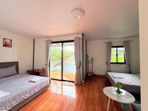 a bedroom with two beds and a table and a window at SODANY RESORT Kohrong in Koh Rong