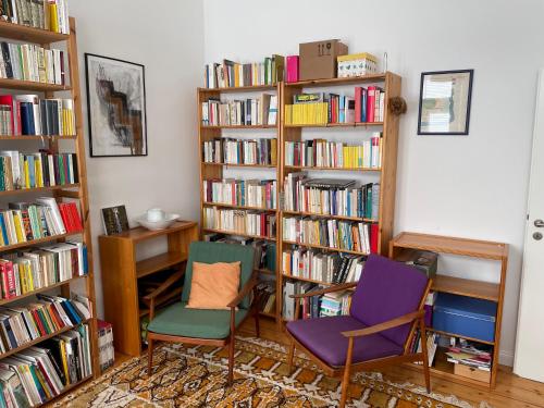 two chairs and a desk in a room with books at Juwel in Neuss, 12 min vom HBF Düsseldorf entfernt in Neuss