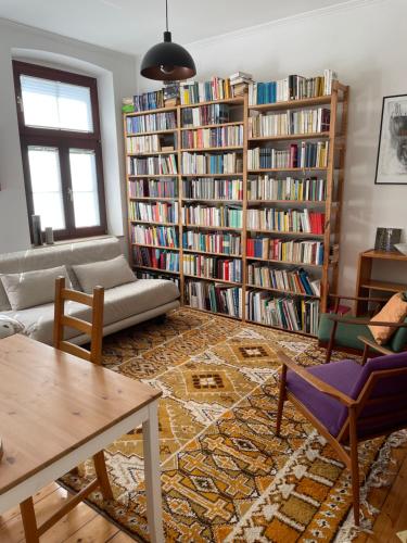a living room with book shelves filled with books at Juwel in Neuss, 12 min vom HBF Düsseldorf entfernt in Neuss