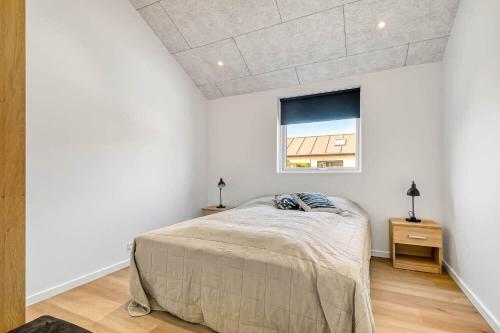 una camera da letto bianca con un letto e una finestra di C11642-Bork-Nordmarken-3 a Falen