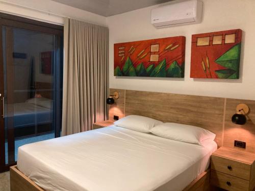 a bedroom with a bed and paintings on the wall at Hacienda Daniela in Cascajero