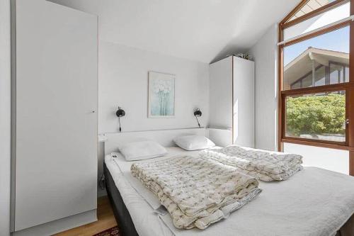 a white bedroom with a bed and a window at SB125-Egernsund-Marinavej-28 in Rendbjerg