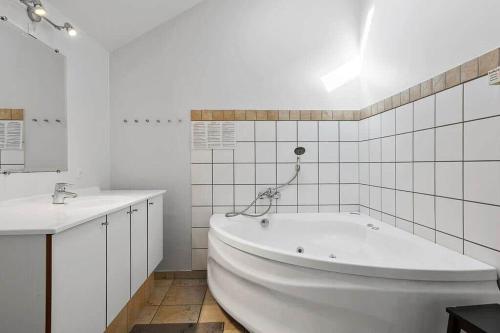 a white bathroom with a tub and a sink at SB125-Egernsund-Marinavej-28 in Rendbjerg