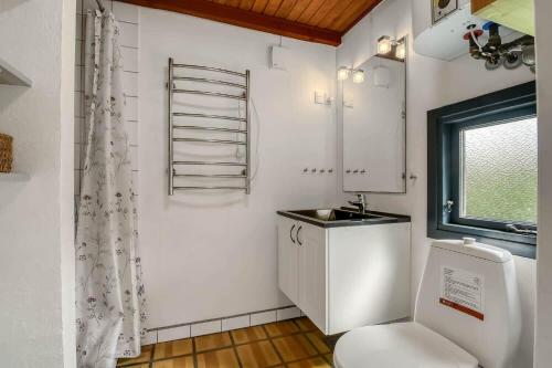 a bathroom with a toilet and a sink and a window at C11693-Hemmet-Bork-Hytteby-144 in Falen