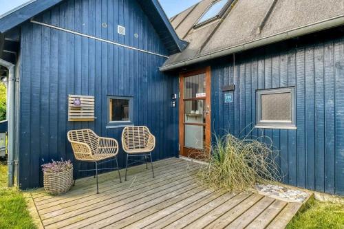a blue building with two chairs on a wooden deck at C11693-Hemmet-Bork-Hytteby-144 in Falen