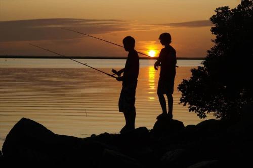 two people fishing in the water at sunset at C11693-Hemmet-Bork-Hytteby-144 in Falen
