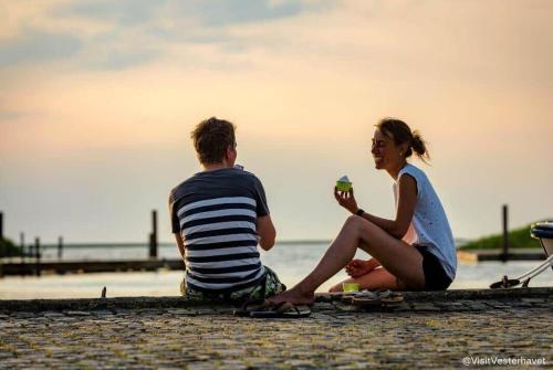 a man and woman sitting on the beach eating ice cream at C11693-Hemmet-Bork-Hytteby-144 in Falen