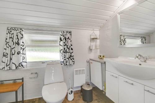 a white bathroom with a toilet and a sink at C11726-Hemmet-Vester-Faelled-120-E1 in Falen