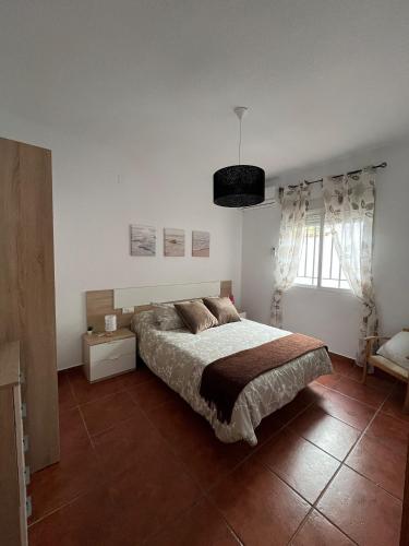 a bedroom with a large bed and a window at Alojamiento Casa Tía Mari in El Robledo