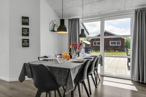 a dining room table with black chairs and a large window at C11349-Tarm-Stikkelsbaervej-43 in Højsand