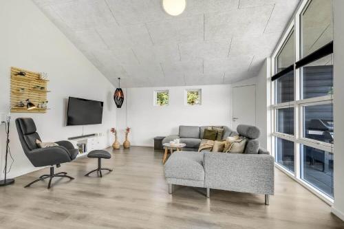 a living room with a couch and chairs and a tv at C11349-Tarm-Stikkelsbaervej-43 in Højsand