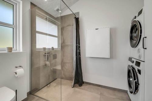 a bathroom with a shower with a glass door at C11349-Tarm-Stikkelsbaervej-43 in Højsand