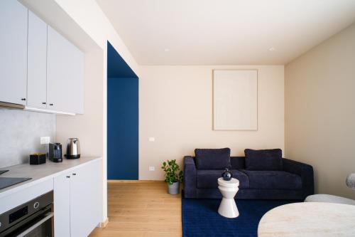 a kitchen and living room with a blue couch at Premier Stay The Garden - Bernina Experience in Tirano