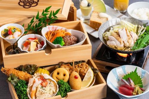 three wooden boxes filled with different types of food at KAMENOI HOTEL Genkainada in Kitakyushu