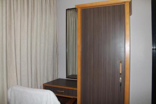 a room with a door with a dresser and a mirror at k2Homes in Pātan