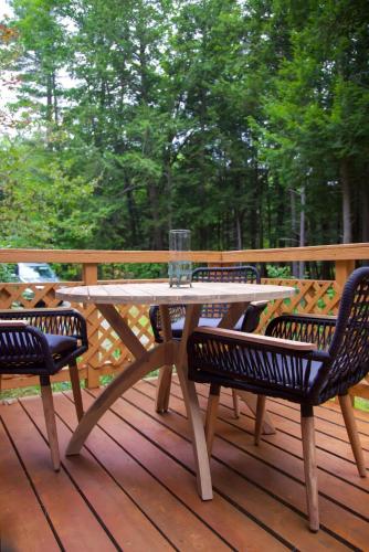 a wooden table and two chairs on a deck at Lincolnville 2BR - Beach Vibes & Backyard BBQ in Lincolnville